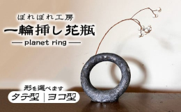 プラネットリング（惑星の輪）をイメージした、一輪挿し。中は空洞になっており、水が入れられます。表面に粘土を何重も重ねており、光によって燻銀、深緑、濃紺などの色が見えます。お花を入れなくても存在感があり
