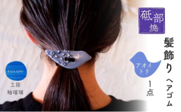 鳥を象った陶ボタンにイッチンが施されたヘアゴム【青い鳥】です。ゴムが伸びたり切れたりしても、付け替えられるボタン（穴あき）タイプですので、長く愛用いただけます。また、ゴムを外して、手作りのバッグや小物
