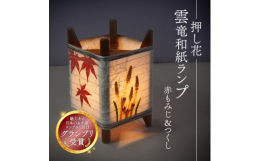 本品は、日本ならではの"美"と"文化"を表現しようと、織物機器の部品を使用して作ったランプです。織り糸をまきつけるための木枠の中央部に発光電球をセットし、丹後和
